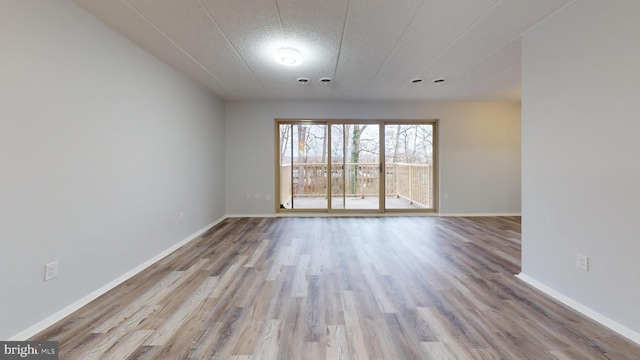 empty room featuring a textured ceiling and light hardwood / wood-style flooring