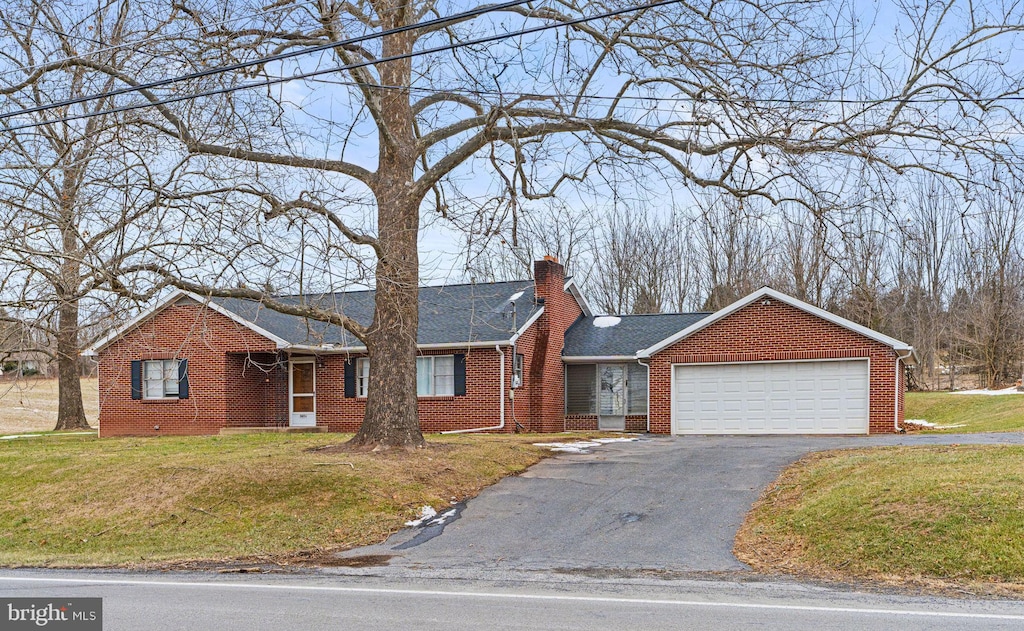 ranch-style home featuring a front lawn and a garage