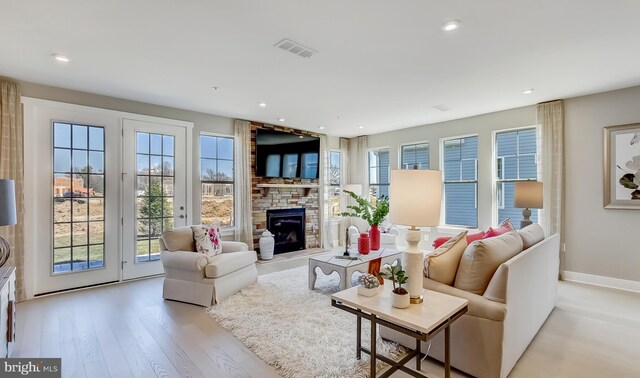 living room featuring a large fireplace and light hardwood / wood-style flooring