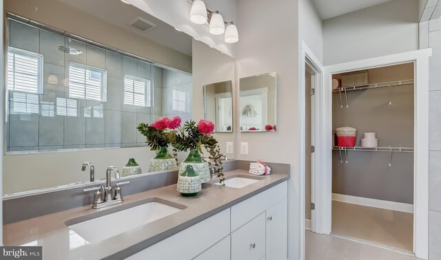 bathroom featuring a shower, vanity, and plenty of natural light