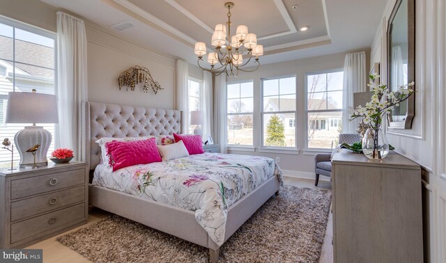 bedroom with a tray ceiling and a notable chandelier