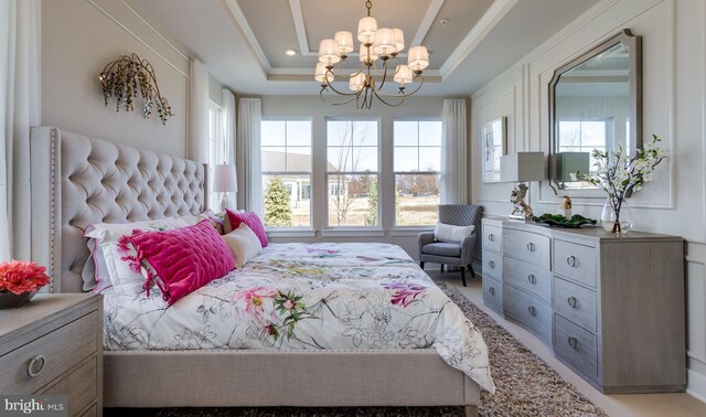 bedroom with a tray ceiling, a chandelier, and ornamental molding