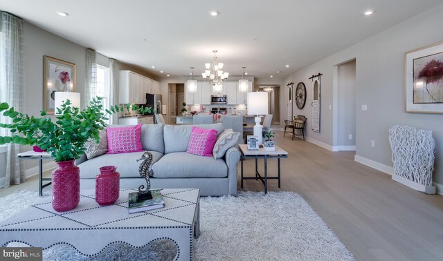 living room with a chandelier and light wood-type flooring