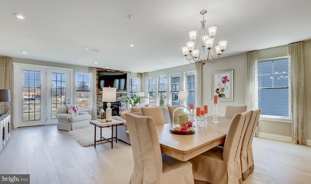 dining area featuring a notable chandelier, plenty of natural light, and light wood-type flooring