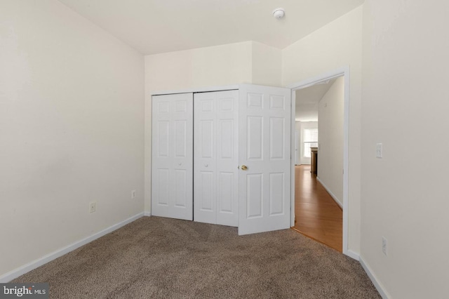 unfurnished bedroom featuring carpet and a closet