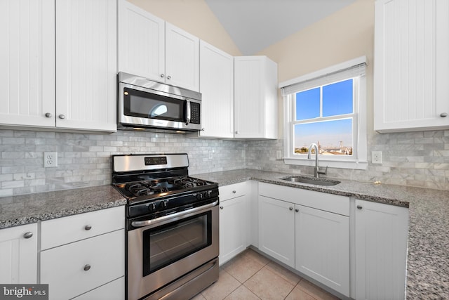 kitchen featuring white cabinetry, sink, stainless steel appliances, and vaulted ceiling