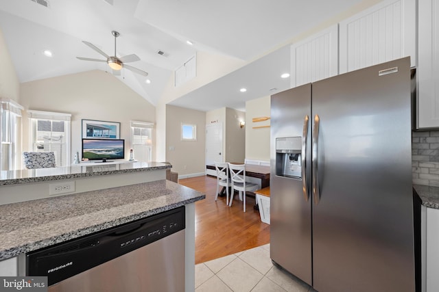 kitchen featuring appliances with stainless steel finishes, light stone counters, vaulted ceiling, ceiling fan, and white cabinets