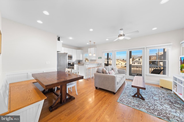 living room featuring light hardwood / wood-style flooring and ceiling fan