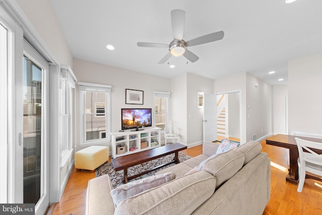 living room featuring ceiling fan and light hardwood / wood-style flooring