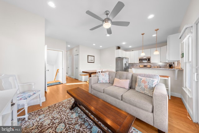 living room with ceiling fan and light wood-type flooring