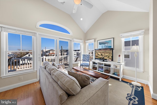 living room with hardwood / wood-style floors, high vaulted ceiling, and ceiling fan