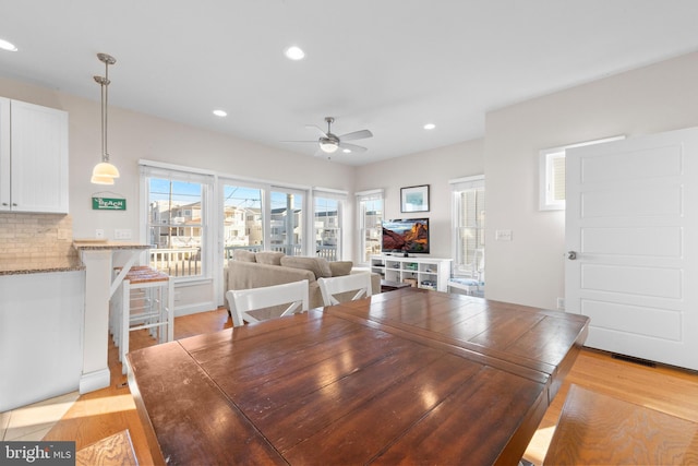 dining area with ceiling fan and light wood-type flooring