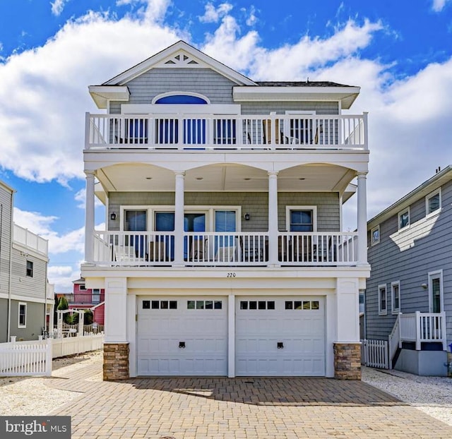 220 Taylor Ave, Beach Haven, NJ 08008 - raised beach house featuring a balcony, decorative driveway, stone siding, and a garage