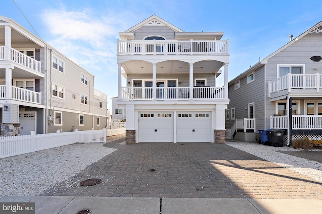 raised beach house featuring a balcony and a garage