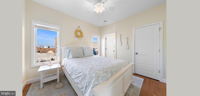 bedroom with light wood-type flooring, multiple windows, and ceiling fan