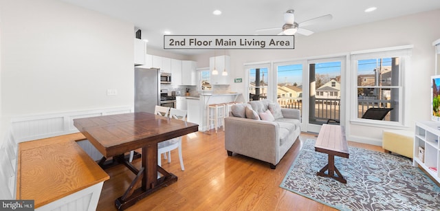 living room with ceiling fan and light wood-type flooring