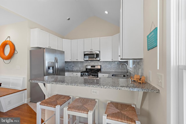 220 Taylor Ave, Beach Haven, NJ 08008 - kitchen with appliances with stainless steel finishes, a sink, a peninsula, light stone counters, and decorative backsplash