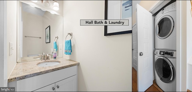 clothes washing area featuring stacked washer / dryer and sink