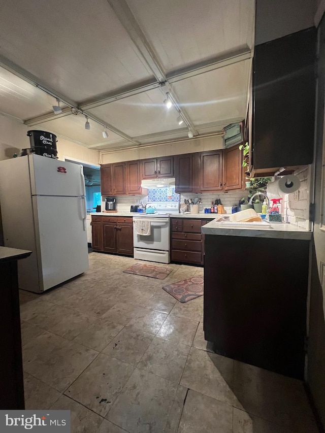 kitchen with dark brown cabinets, white appliances, and backsplash