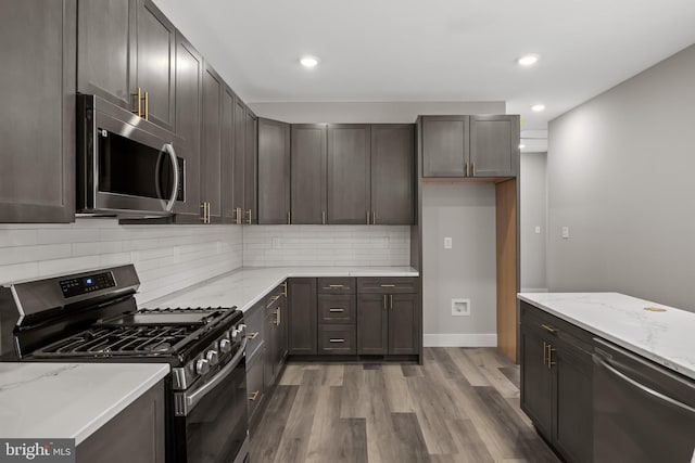 4540 Lake Rd, Newfield, NJ 08344 - kitchen featuring appliances with stainless steel finishes, wood finished floors, tasteful backsplash, light stone counters, and recessed lighting