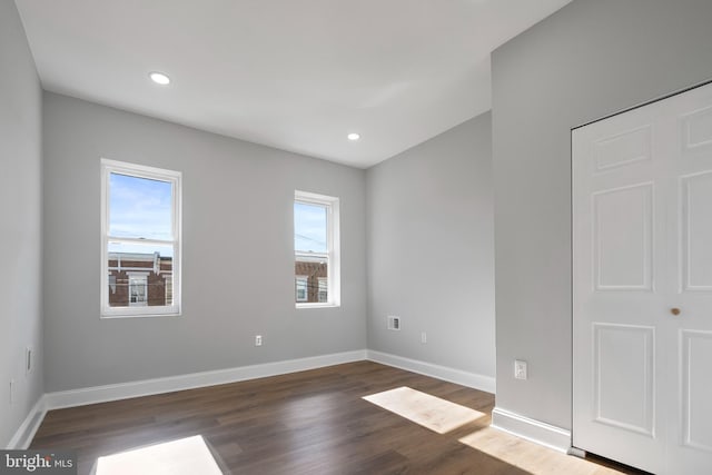 empty room with dark hardwood / wood-style flooring