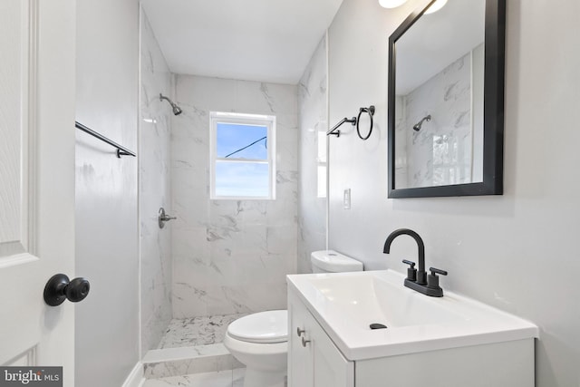 bathroom with vanity, toilet, and a tile shower