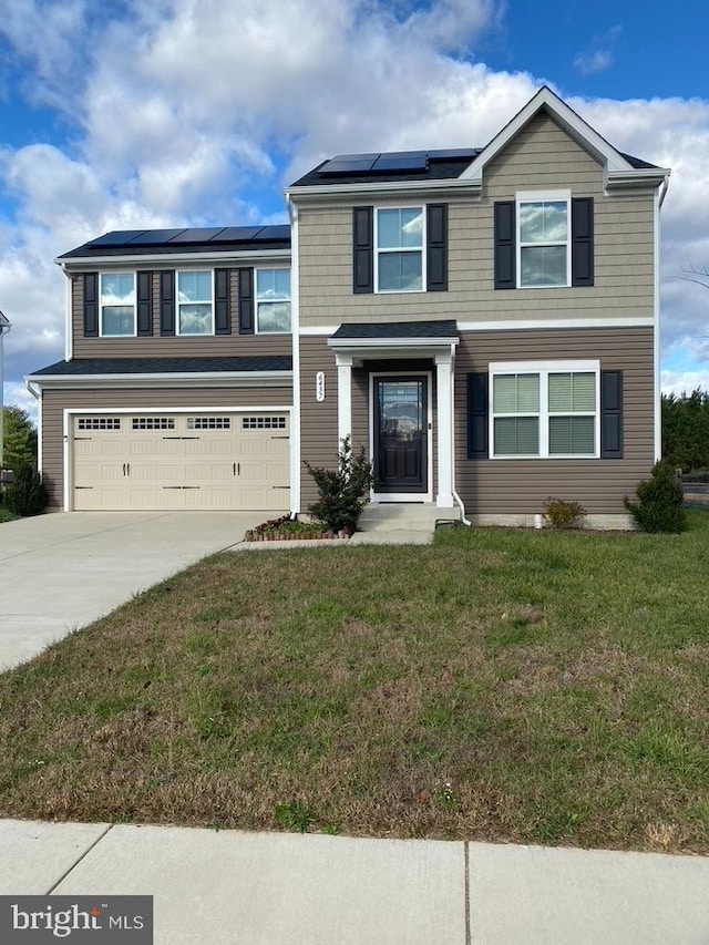 view of front of property with solar panels, a garage, and a front lawn