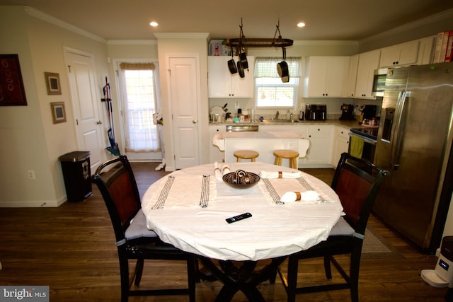 dining space featuring crown molding, dark wood-type flooring, and sink