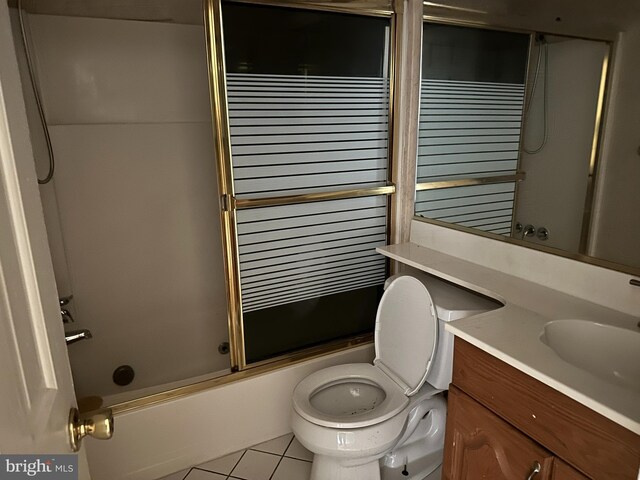 full bathroom with shower / bath combination with glass door, tile patterned flooring, vanity, and toilet