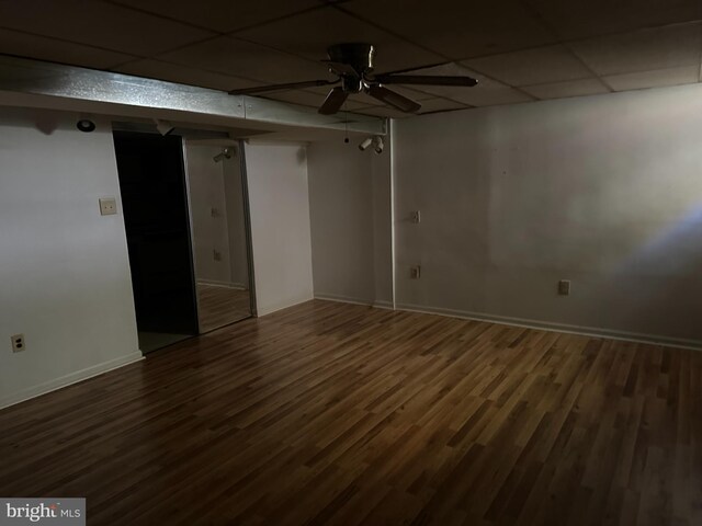 unfurnished room featuring a paneled ceiling, ceiling fan, and dark wood-type flooring