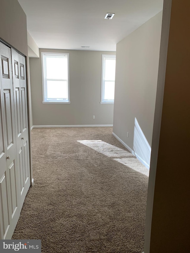 carpeted empty room featuring plenty of natural light