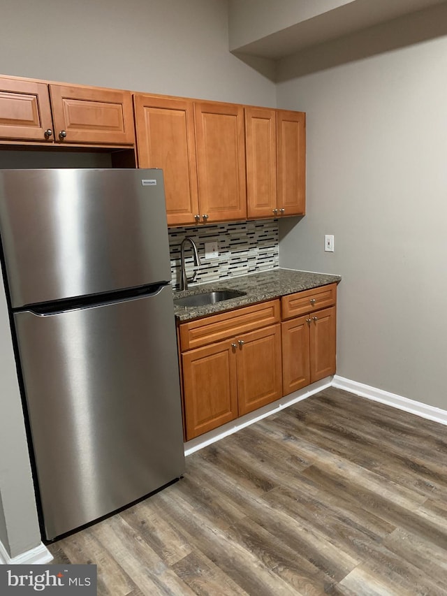 kitchen with dark hardwood / wood-style flooring, sink, stainless steel refrigerator, and tasteful backsplash