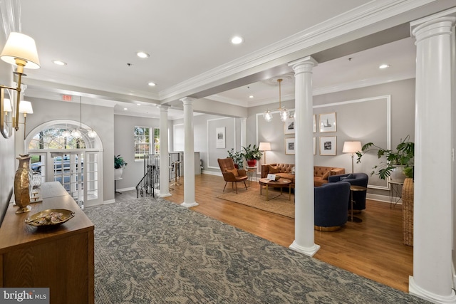 foyer entrance featuring hardwood / wood-style flooring, crown molding, and a notable chandelier