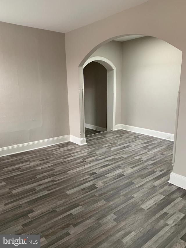 unfurnished room featuring dark wood-type flooring