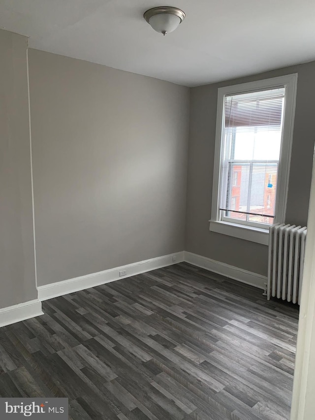 empty room with radiator and dark wood-type flooring