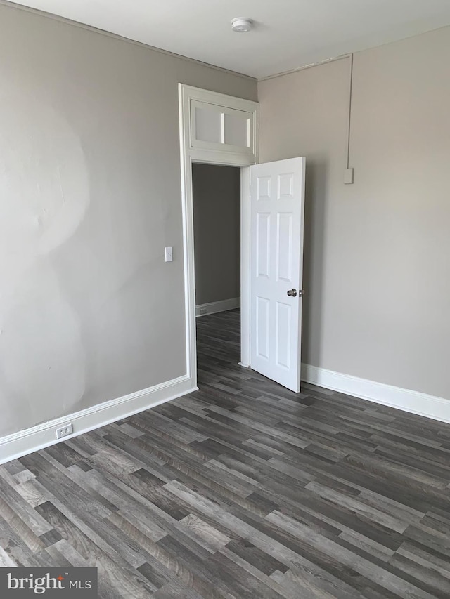 spare room featuring dark wood-type flooring