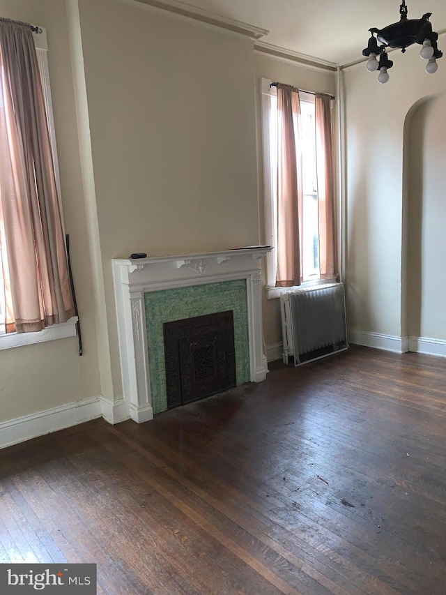 unfurnished living room with dark hardwood / wood-style flooring and radiator