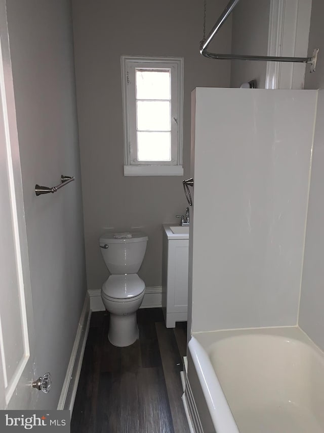 full bathroom with hardwood / wood-style flooring, vanity, toilet, and washtub / shower combination