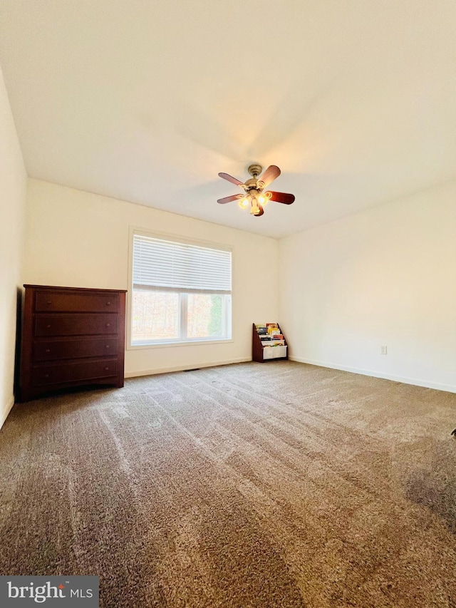 spare room featuring carpet and ceiling fan