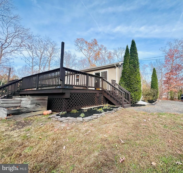 back of property with a wooden deck and a yard