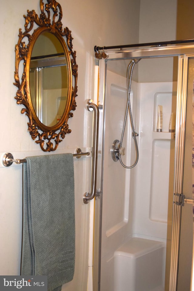 bathroom with a shower with door