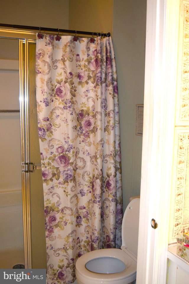 bathroom featuring a shower and toilet