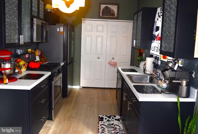 kitchen with sink, stainless steel appliances, and light wood-type flooring