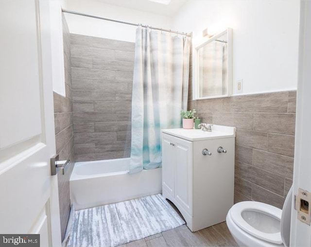 full bathroom with hardwood / wood-style floors, vanity, shower / bath combination with curtain, toilet, and tile walls