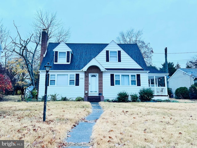 cape cod-style house with a front yard