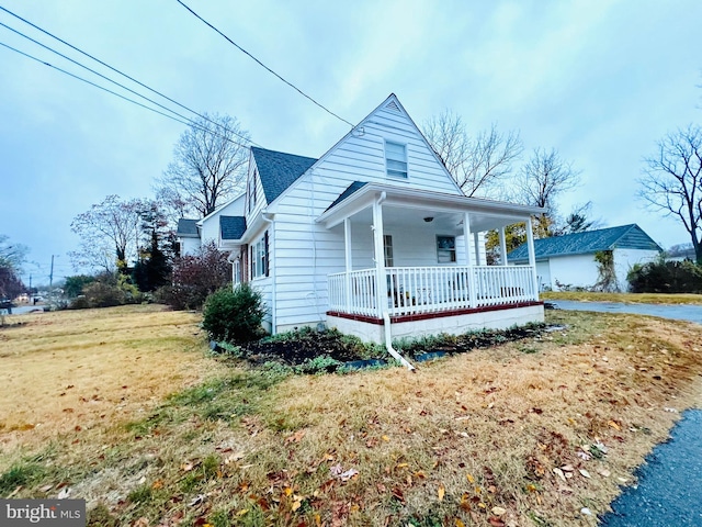 view of front of property featuring covered porch and a front lawn