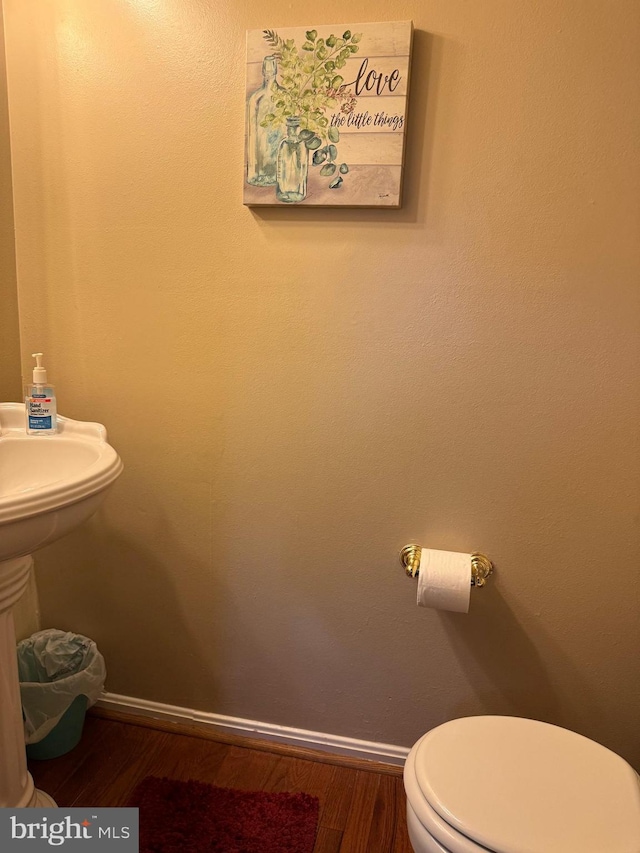 bathroom featuring toilet and wood-type flooring