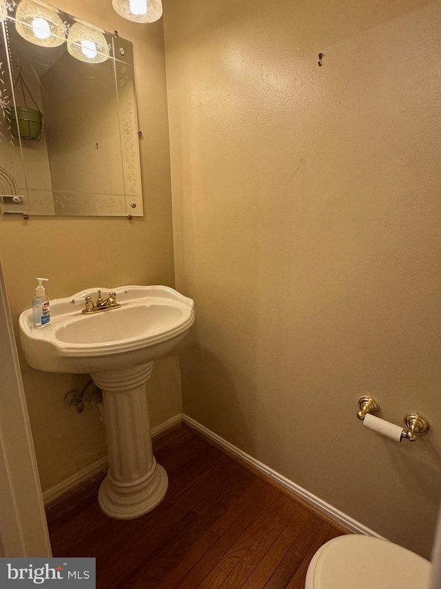 bathroom with hardwood / wood-style floors and toilet