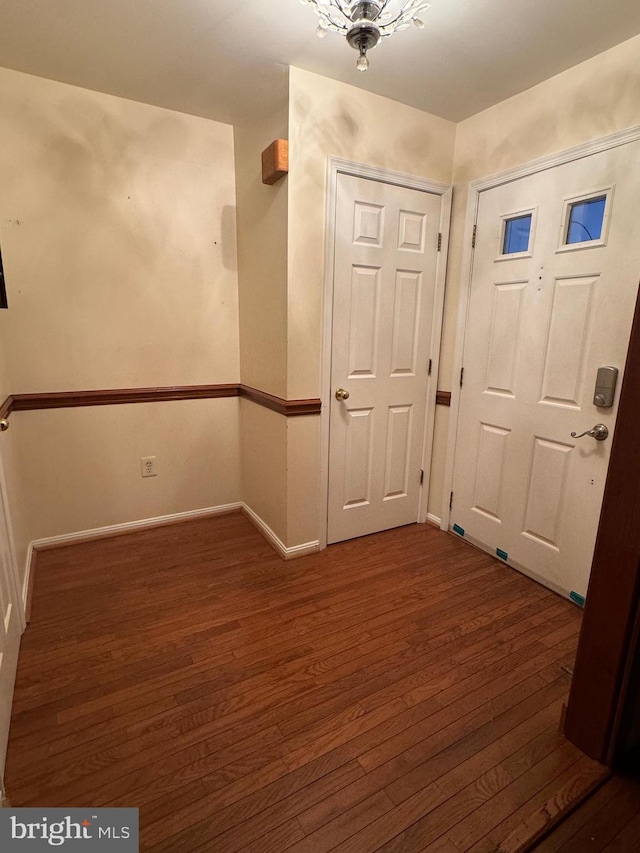 interior space featuring dark hardwood / wood-style flooring and an inviting chandelier