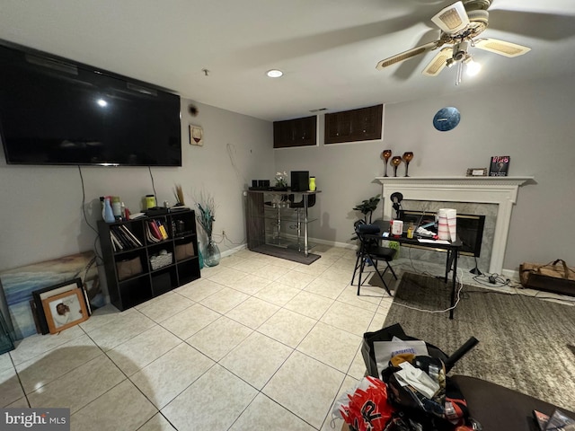 tiled living room with ceiling fan and a tile fireplace